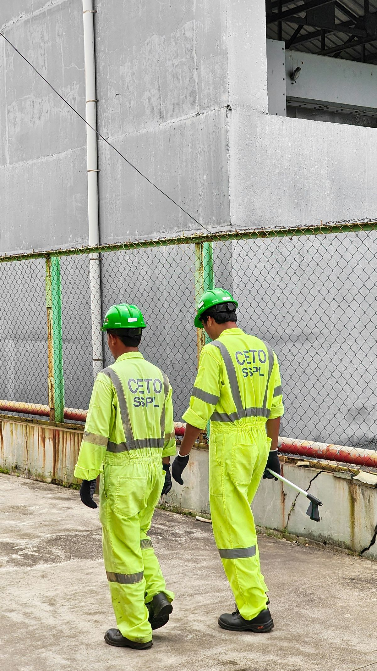 Flame-resistant coveralls and safety boots on a rack